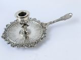 a silver plate with a candle holder on top of it