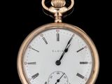 gros plan d'une montre de poche en or sur fond noir