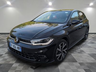 une Volkswagen Golf noire garée dans un garage au sol carrelé