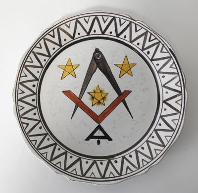 une assiette décorative ornée d'un symbole maçonnique