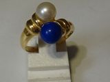 une bague ornée d'une perle et d'une pierre bleue