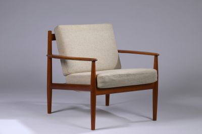 La chaise est en bois et son assise est rembourrée de couleur beige.
