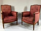 paire de fauteuils rembourrés rouges avec structure en bois et accoudoirs rembourrés