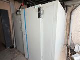 un réfrigérateur posé dans un coin d'un immeuble