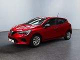 Une voiture rouge est garée dans une pièce aux murs blancs.