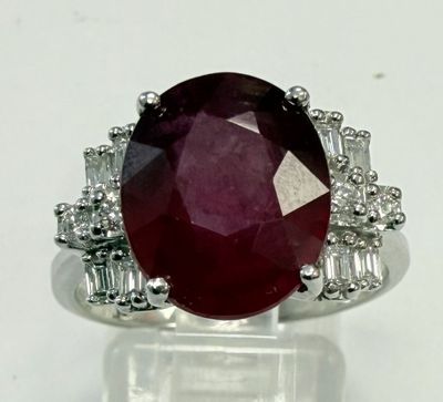 gros plan d'une bague avec une pierre rouge entourée de diamants blancs