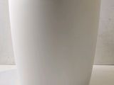 a white cup with a black rim sitting on a table