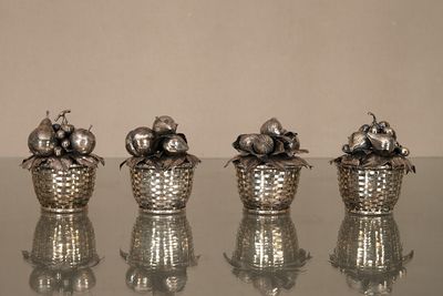 trois vases en argent posés sur une table en verre
