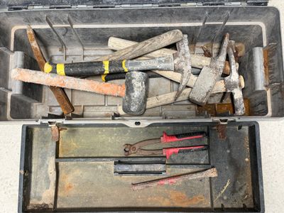 de nombreux outils dans une boîte à outils posée par terre
