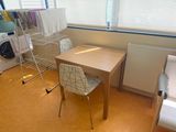 a small table and chair in a room with a window