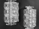 pair of wall sconces made of clear glass with a metal base