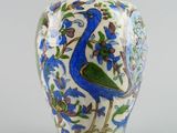 a blue and white vase with a peacock on it