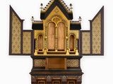a small wooden shrine with a cross on top