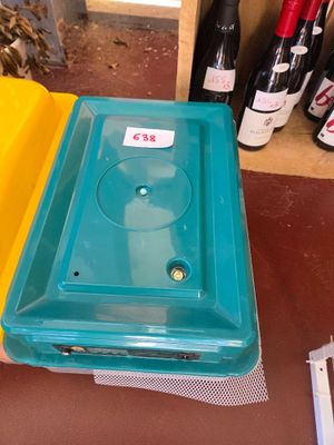 bottles of wine are sitting on a table next to a plastic container