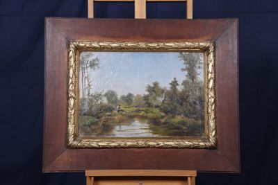une peinture à l'huile représentant une rivière et des arbres, dans un cadre en bois