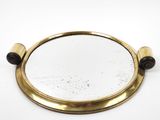 brass plated mirror with wooden handles on a white surface