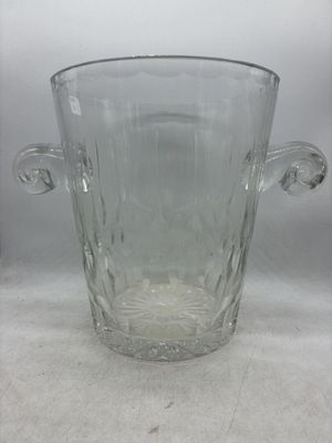 un vase en verre transparent avec une anse sur une table