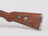 an old wooden rifle with a metal muzzle on a white background