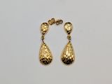 a pair of gold toned earrings on a white surface