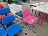 many different colored chairs and tables in a room