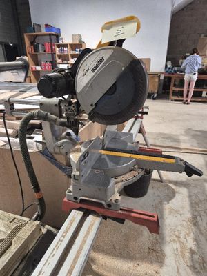 quelqu'un utilise une scie circulaire pour couper une pièce de bois
