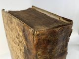 an old book sitting on top of a white table next to a white wall