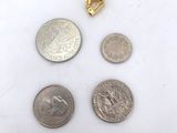 three coins and a quarter are sitting next to each other on a white surface
