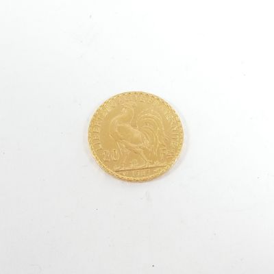 gros plan d'une pièce d'or sur une surface blanche