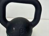 a black kettlebell with a green stripe on it