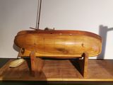 a small wooden boat on a wooden stand on a table