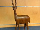 a wooden sculpture of a antelope in a room