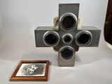 a metal cross on a table next to a picture frame
