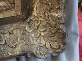 a close up of a gold frame with a bird on it