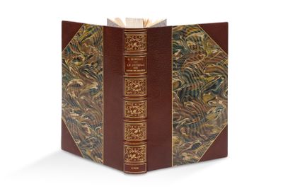 un vieux livre à la couverture brune et à la bordure dorée