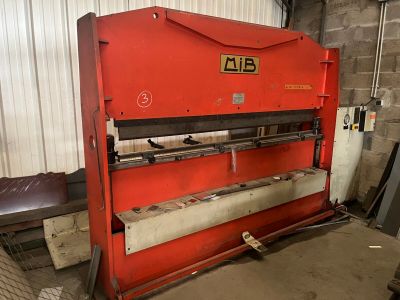 Une image représentant une grande machine rouge se trouve dans un entrepôt.