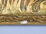 a close up of a gold frame with a bird on it