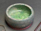 a green bowl sitting next to a pair of chopsticks and a pair of scissors