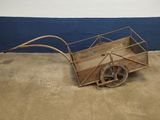 a small wooden cart with a metal handle on the ground