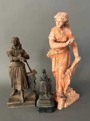 deux statues représentant une femme et un homme debout l'un à côté de l'autre