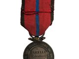 an old medal with a red and blue ribbon on a white background