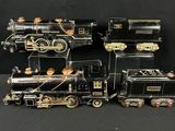 deux locomotives noires et dorées placées côte à côte sur une surface noire
