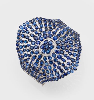 un gros plan sur une bague sertie d'un saphir bleu et de diamants
