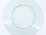 a white plate with a gold rim sitting on a table