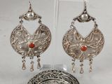 a close up of a pair of earrings on a stand