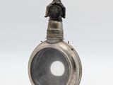 une bouteille ancienne en argent surmontée d'une statuette