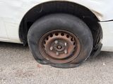 a white car that has a flat tire on it