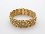 un bracelet en maille dorée muni d'un fermoir, sur fond blanc