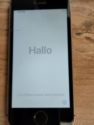 a cell phone sitting on a wooden table with a hello message on the screen