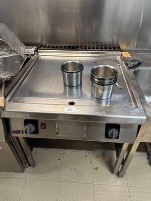 une cuisinière en acier inoxydable sur laquelle sont posées deux casseroles
