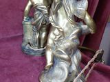 two figurines of a boy and a girl on a bench